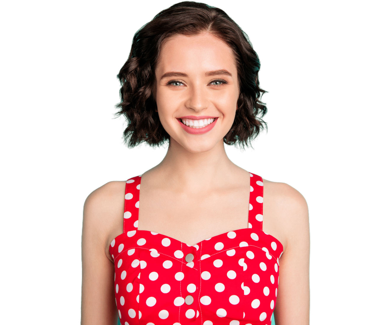 A person with short, curly hair is smiling, wearing a red polka dot dress. The background is plain white.